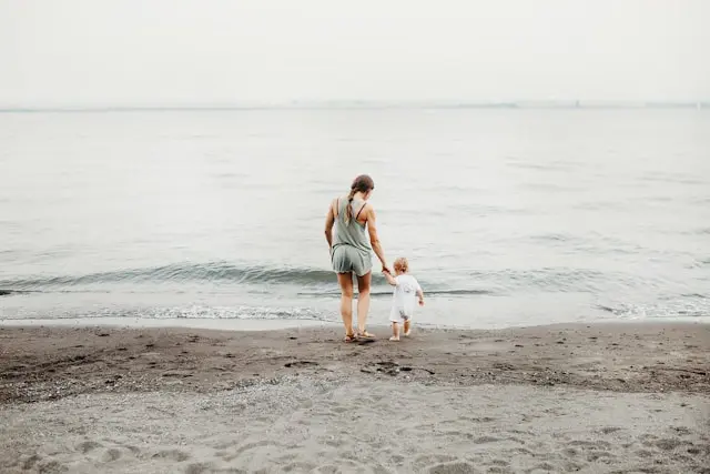 Mutter und Kind erkunden den Strand
